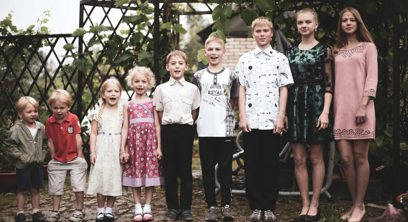 a row of children from a family standing in order of height