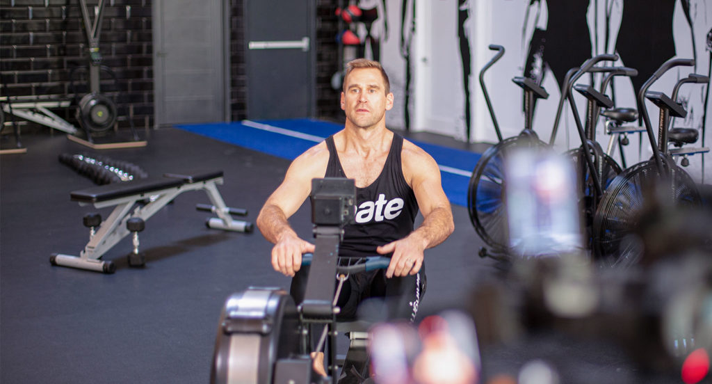 Celebrity Trainer Luke Milton on a row machine in a gym