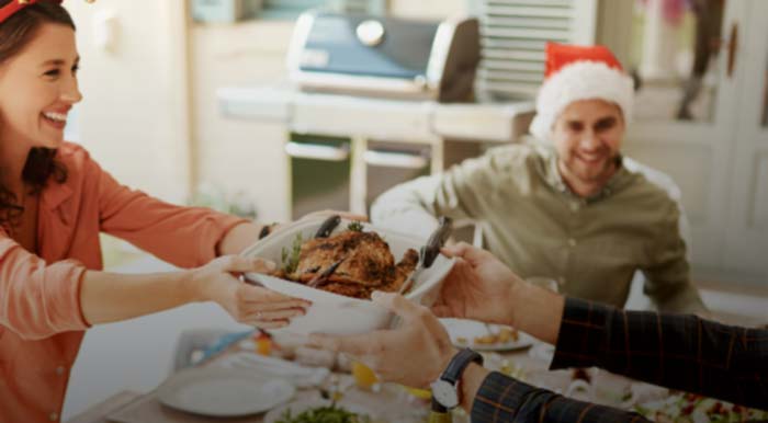 a family sharing a roast outside at a festive celebration