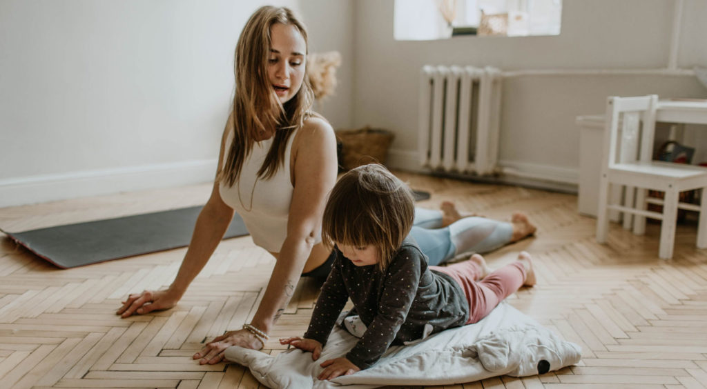 a woman and her young child doing yoga in her apartment