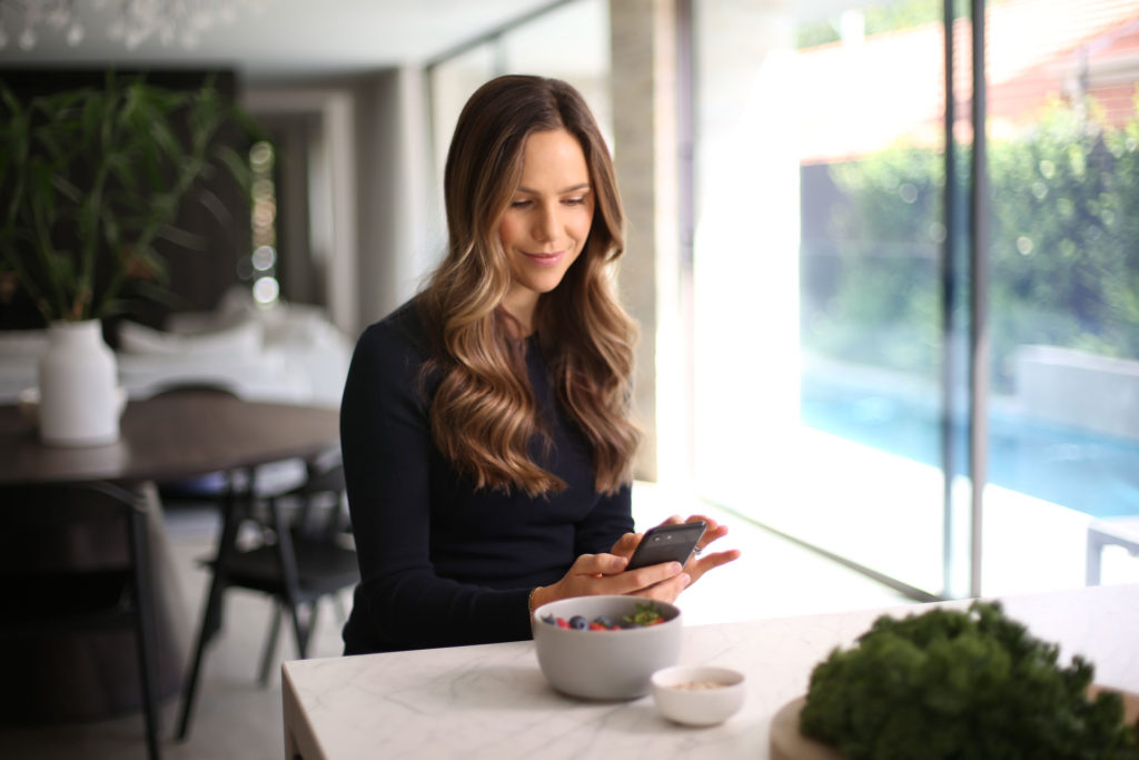 Nutritionist Alex Pendlebury browsing myDNA insights on her phone at home in her kitchen