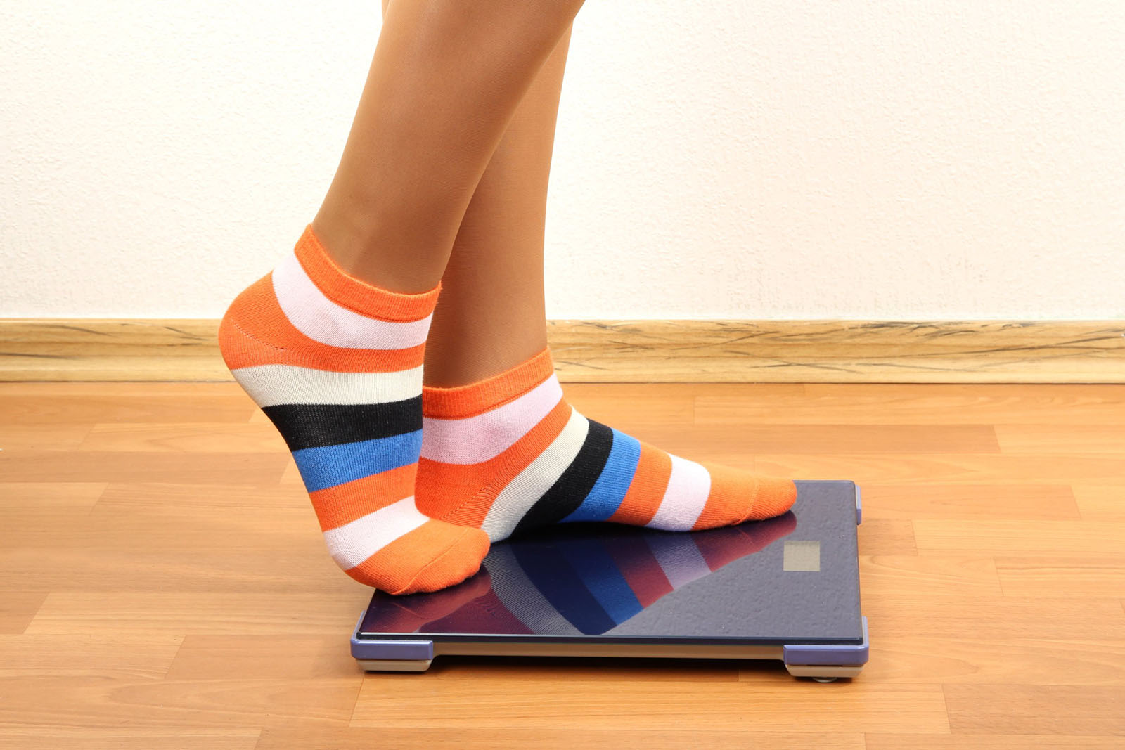 a person in striped socks standing on a scale