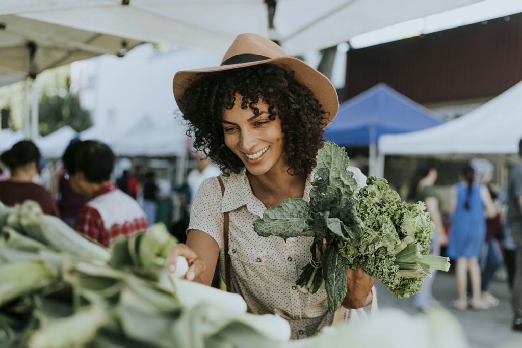 woman picking out meal plan ingredients at a market