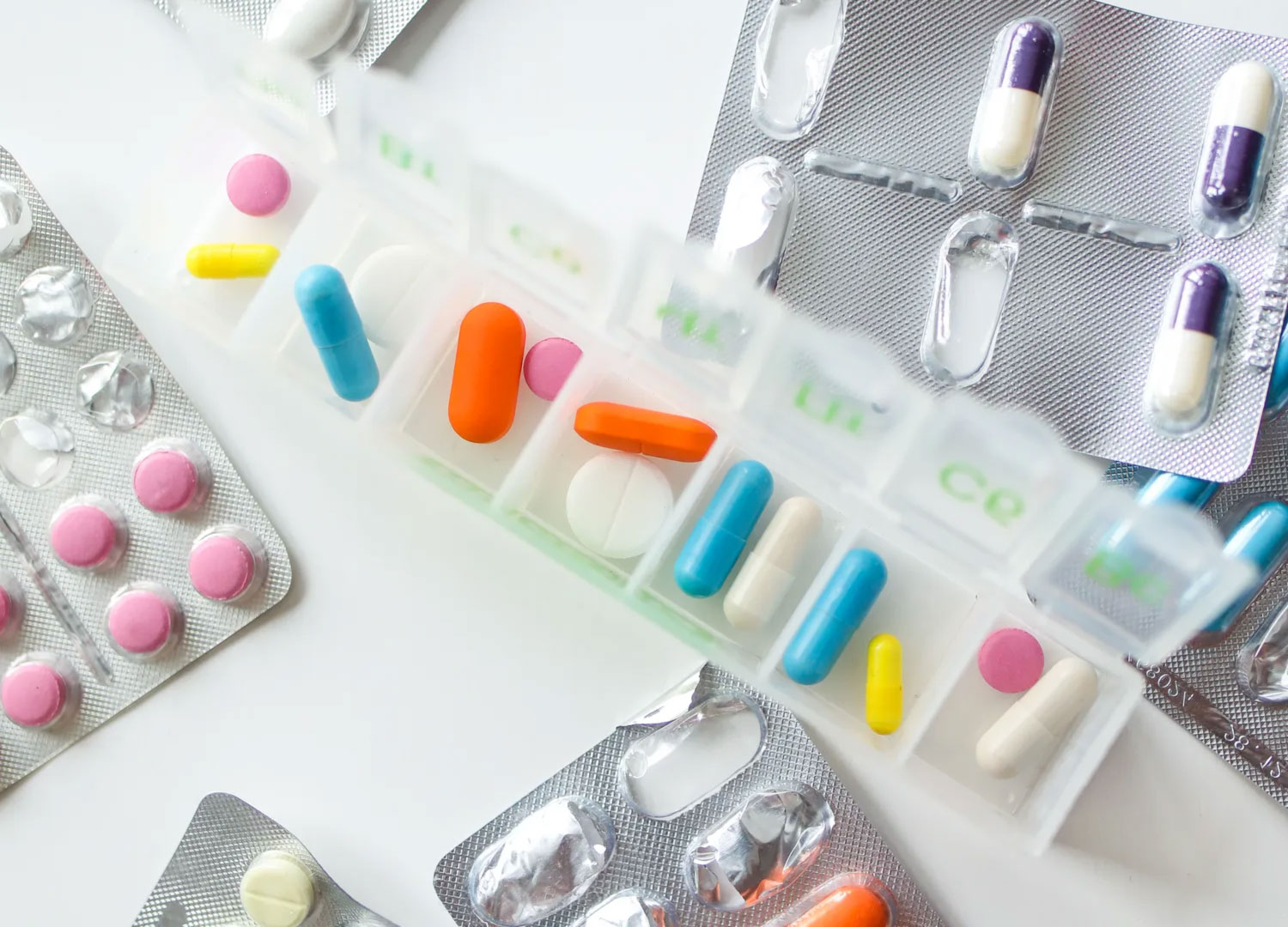 an assortment of medications in and around a plastic container