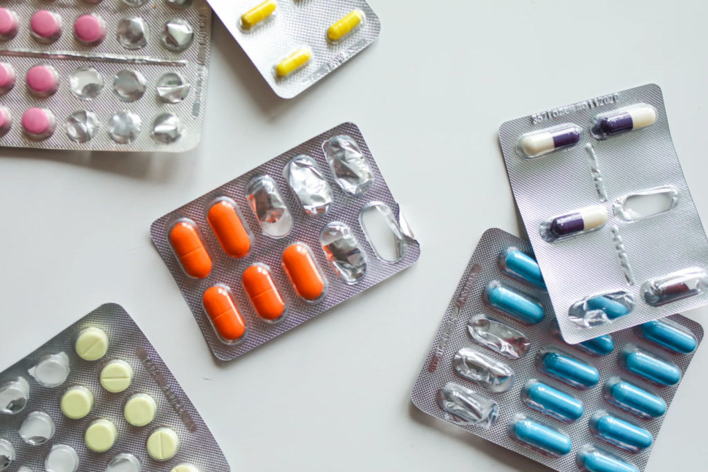 various coloured pills in foil packaging on a table