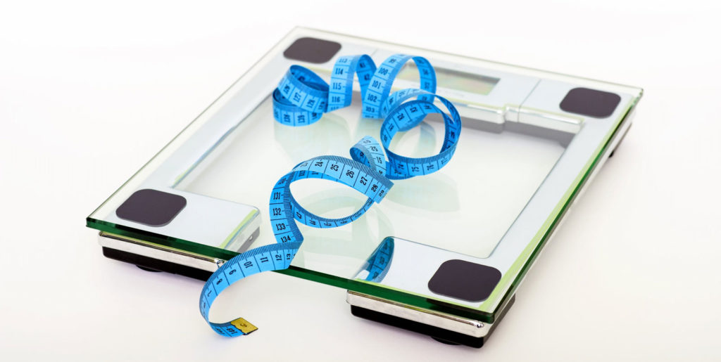 an electronic set of scales with a blue measuring ribbon