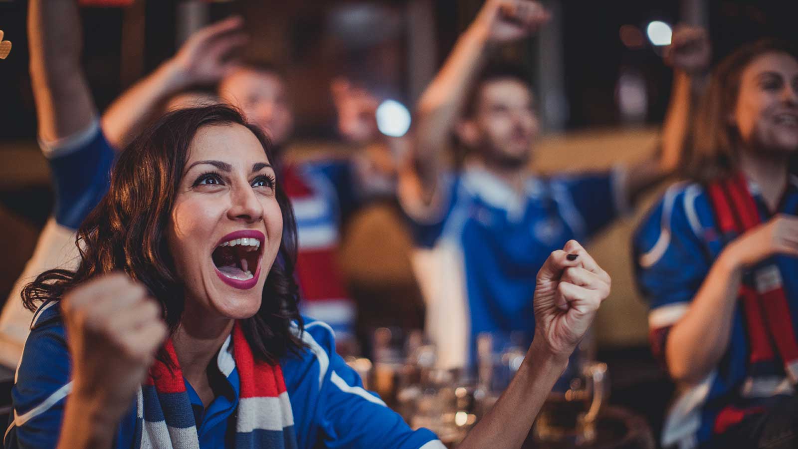 sports fans wearing team gear cheering their team on