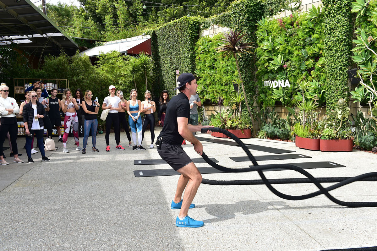 Luke Milton working out with ropes while other fitness aficionados watch at the myDNA US launch