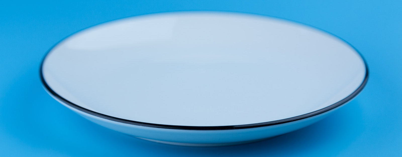 an empty plate on a blue surface