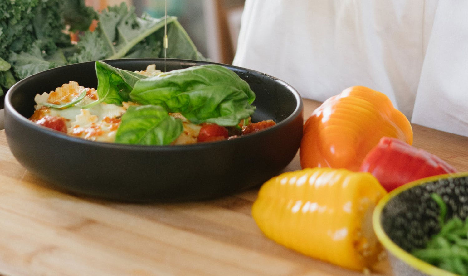 a chef pouring dressing onto a delicious and healthy salad in a kitchen