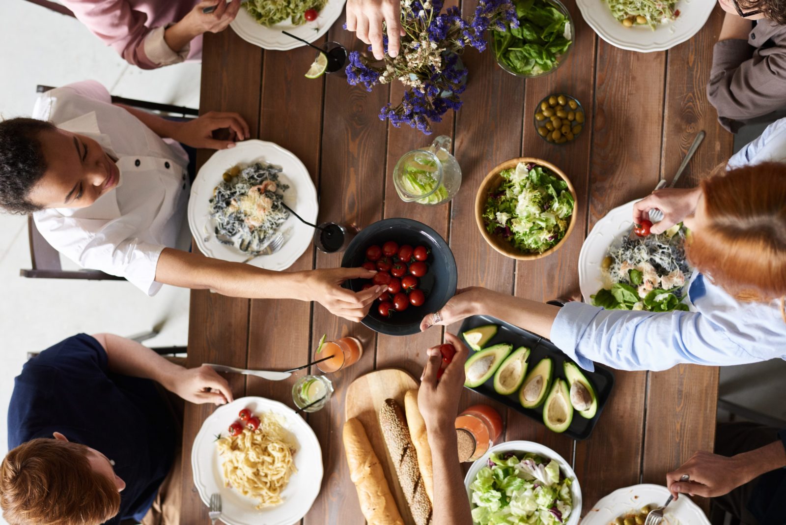 top view of several people at a table sharing a healthy assortment of food