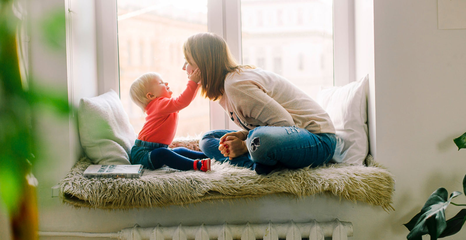 woman with one of her kids playing at a window