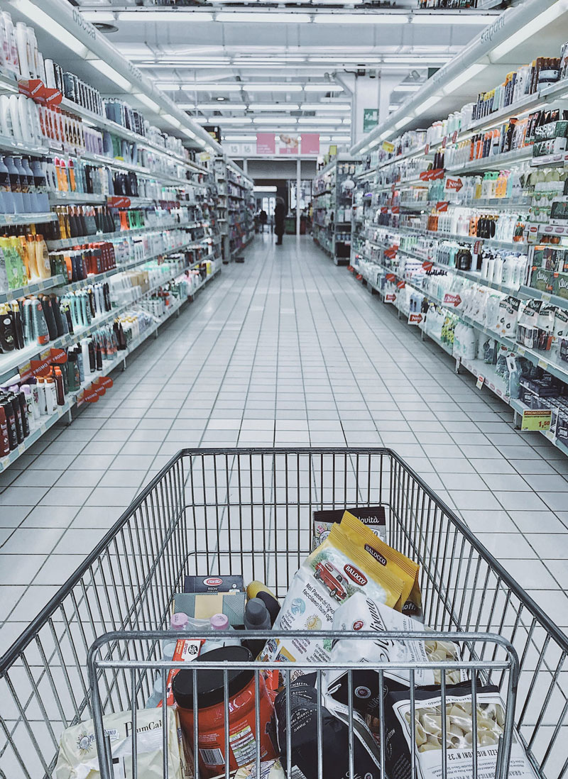 point of view photo of a shopping cart looking down an aisle