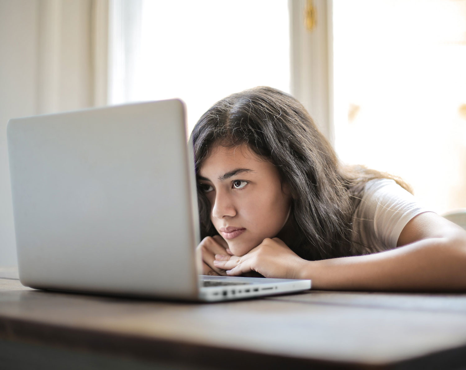 a young girl starting intensely at a laptop screen