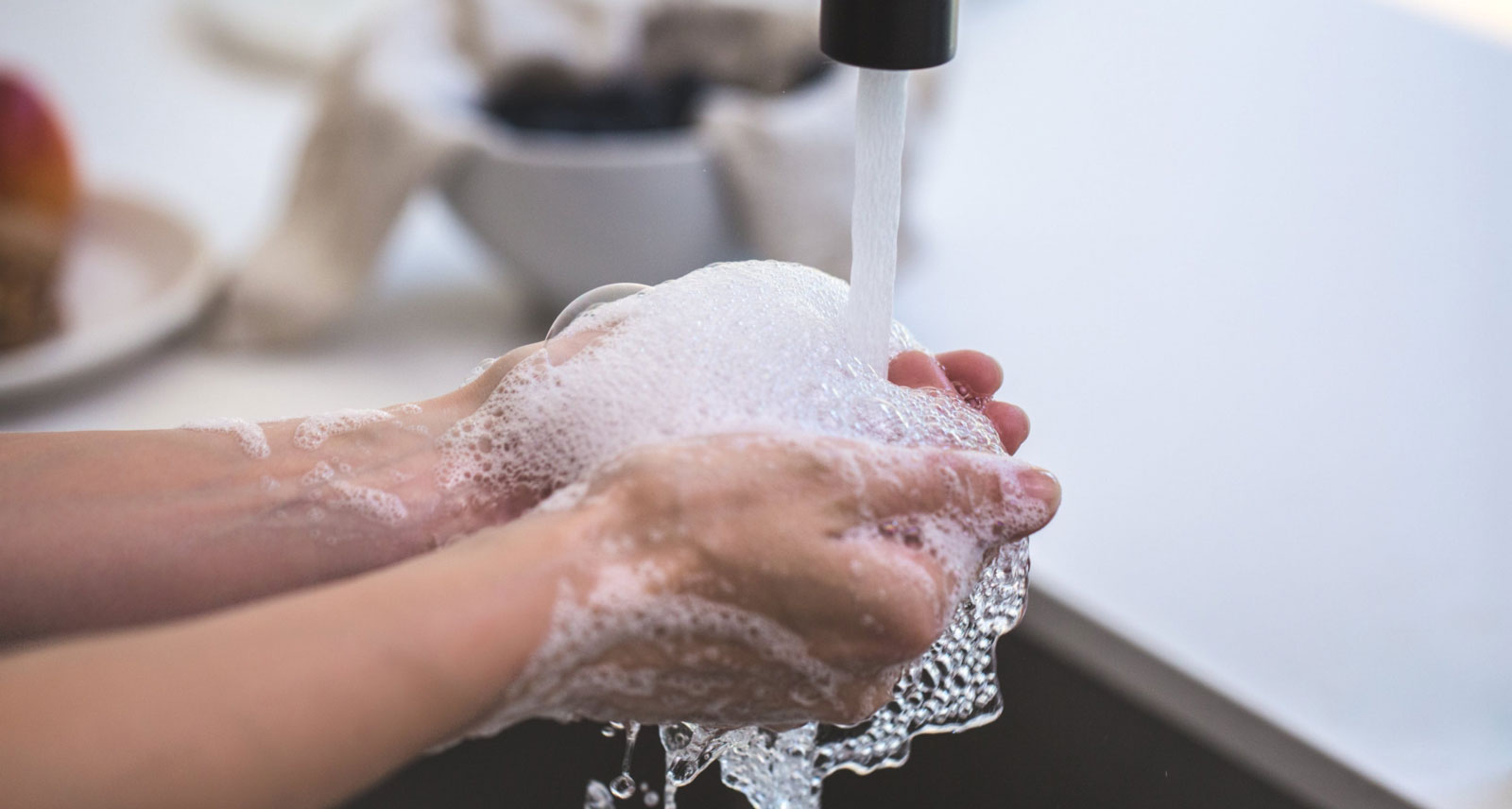 a person washing their hands with soap under running water