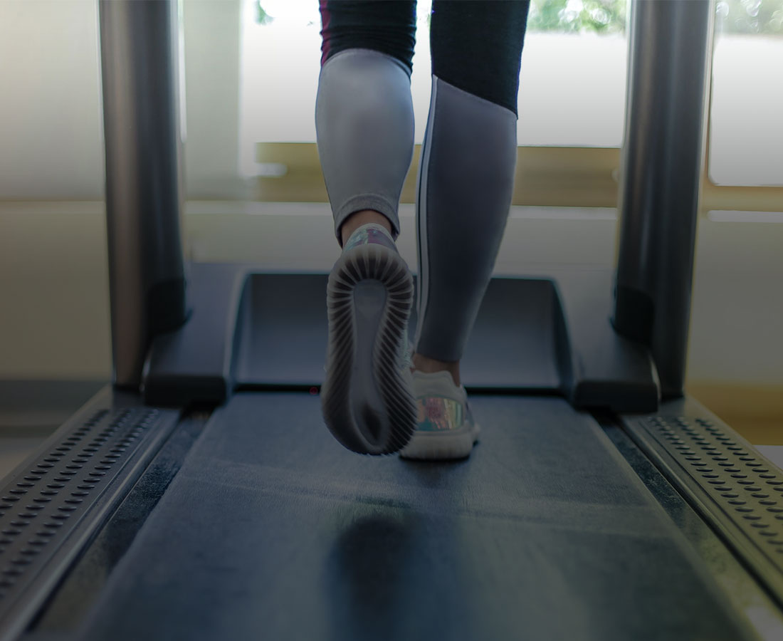 a close up shot of a woman running on a treadmill