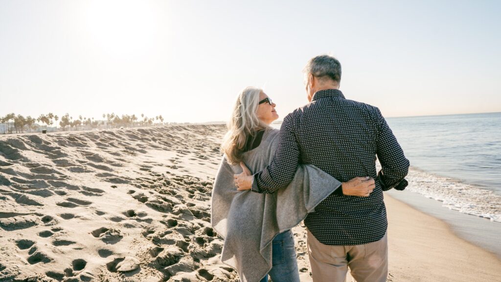 Couple Walking on the beach and the female is looking at her male partner