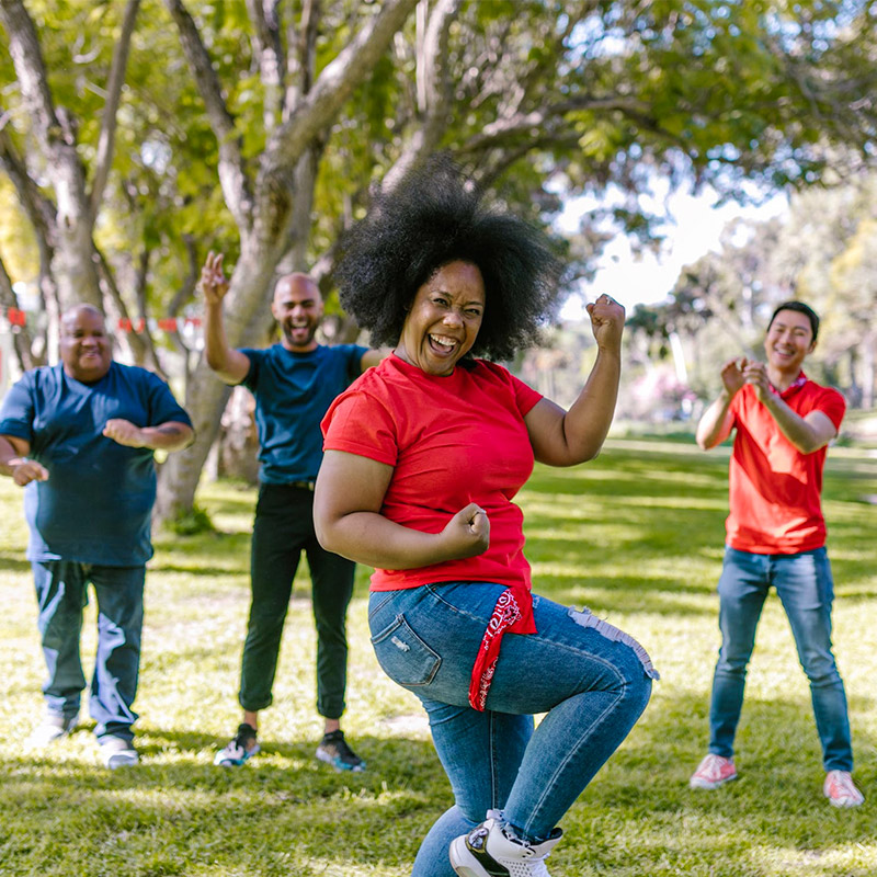 a black woman in the park with jeans and a red shirt