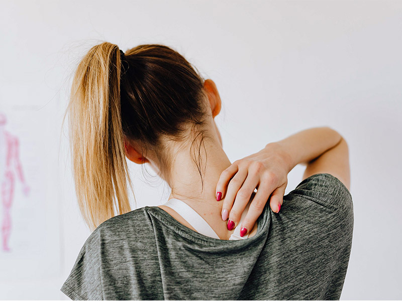 a brunette woman at a physician experiencing back pain