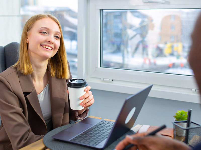 a businesswoman with red hair holding a takeaway coffee