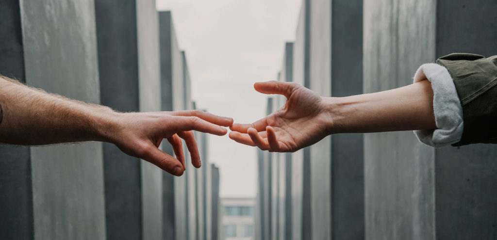 a close up of two people's arms reaching out for each other