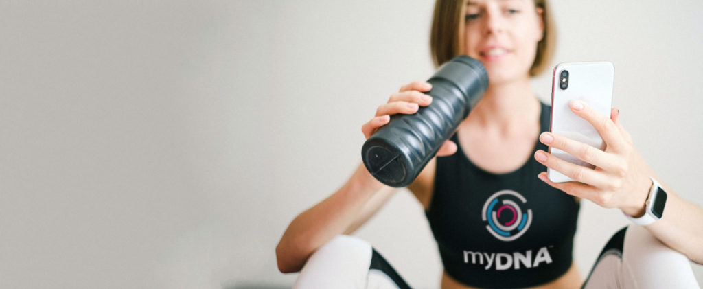 a female myDNA member in activewear checking her insights on a phone