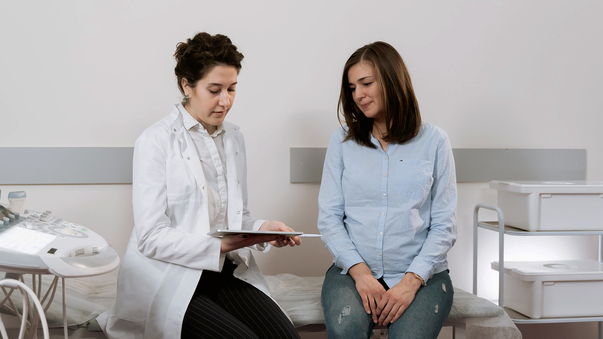 a woman in a blue shirt having a consultation with a doctor